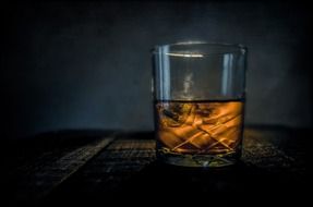 whiskey in glass at darkness