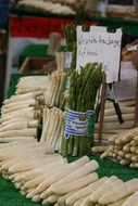 bunch of asparagus among vegetables on market