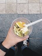 fruit salad in cup in person’s hand outdoor