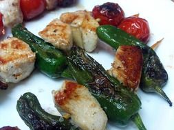 skewers chicken and grilled vegetables on the white surface