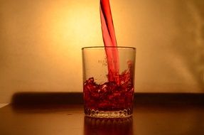 pouring red liquid into the glass