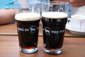 two glasses of alcoholic dark beer