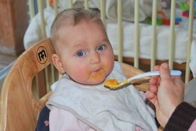 feeding baby in a baby chair