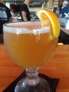 a glass of beer with a slice of orange