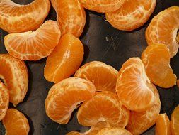 mandarin slices on dark surface