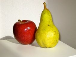 Beautiful Still life of red apple and green and yellow pear at white wall background