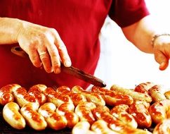 man cooking sausage on grill