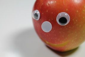 fake eyes and mouth taped to an apple