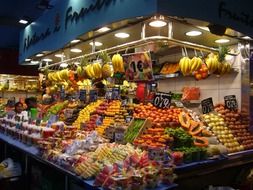 huge stand in the market with a large selection of fruits
