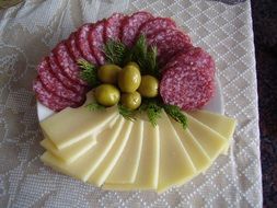 slicing sausage and cheese with olives