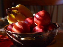 nectarines and bananas in a bowl