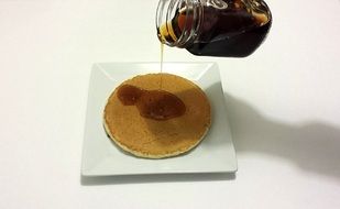 dark honey pouring on pancake