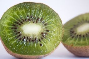 cut kiwi into two parts at white background