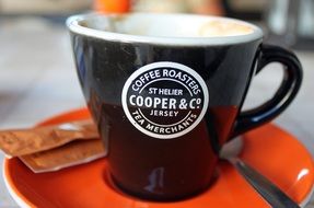 black cup for coffee on an orange saucer