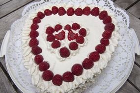 cake in the shape of a heart with raspberries