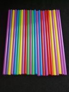 colorful plastic straws on a black background