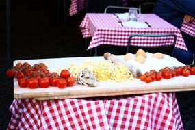 A lot of tomatoes and pasta on a board