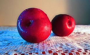 two red plums on the table close-up