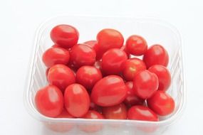 a small pile of cherry tomatoes in a plastic box