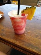 lava flow cocktail with pineapple on a wooden table