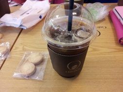 americano with ice in a plastic glass with a straw