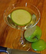 alcohol drink with slice of green apple in glass