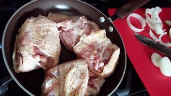 raw chicken thigh in the pan