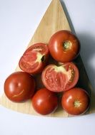 Whole and sliced ââtomatoes on a chopping board