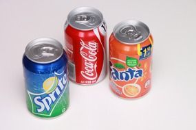 can of coca cola, can of sprite and fanta