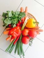 Colorful fresh vegetables and greens for salad on the kitchen table