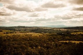 Beautiful landscape with the colorful forest and hills under the cloudy sky