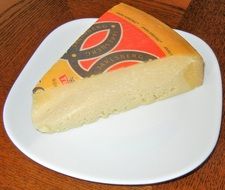 A slice of cheese on a white plate