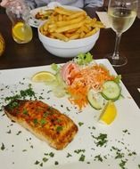 fried fish with vegetables in a restaurant on a white plate