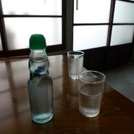 water in a transparent bottle with two glasses