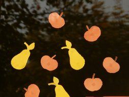 Paper pears and apples on the window