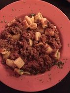 pasta bolognese on a red plate