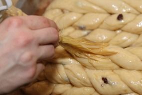 the cook smears the dough with fat close-up