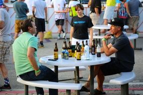 Two men outdoors eating drinking