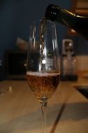 pouring champagne into a glass from a bottle