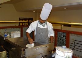 indian cook prepares pancakes