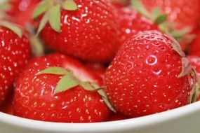 red strawberries in a white bowl