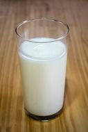 milk in glass on wooden table