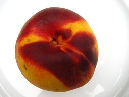 ripe peach on a white plate