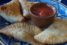 chebureki with tomato souce on a colorful plate