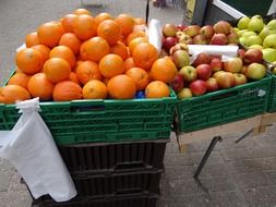 oranges and apples in boxes on the market