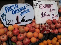 boxes of pomegranates with price tags on the market