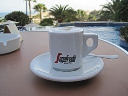 white coffee cup on a table in the open