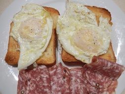 fried eggs, white bread and salami