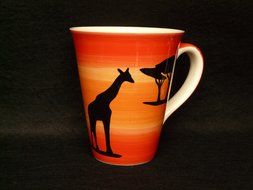 Orange and yellow cup with giraffe in the Africa