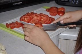 cutting fresh tomatoes on the board